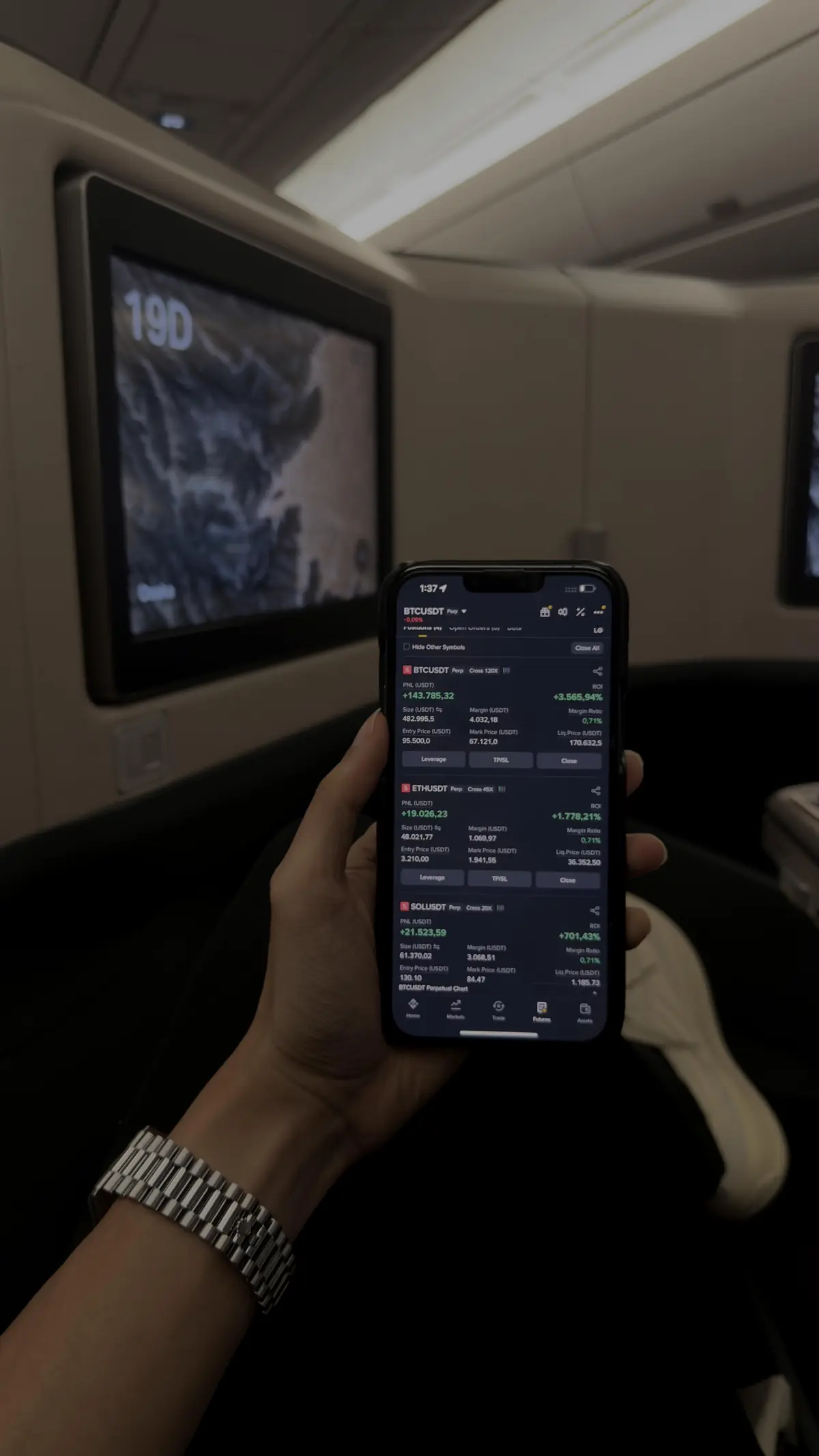Checking a trading app on a phone while travelling